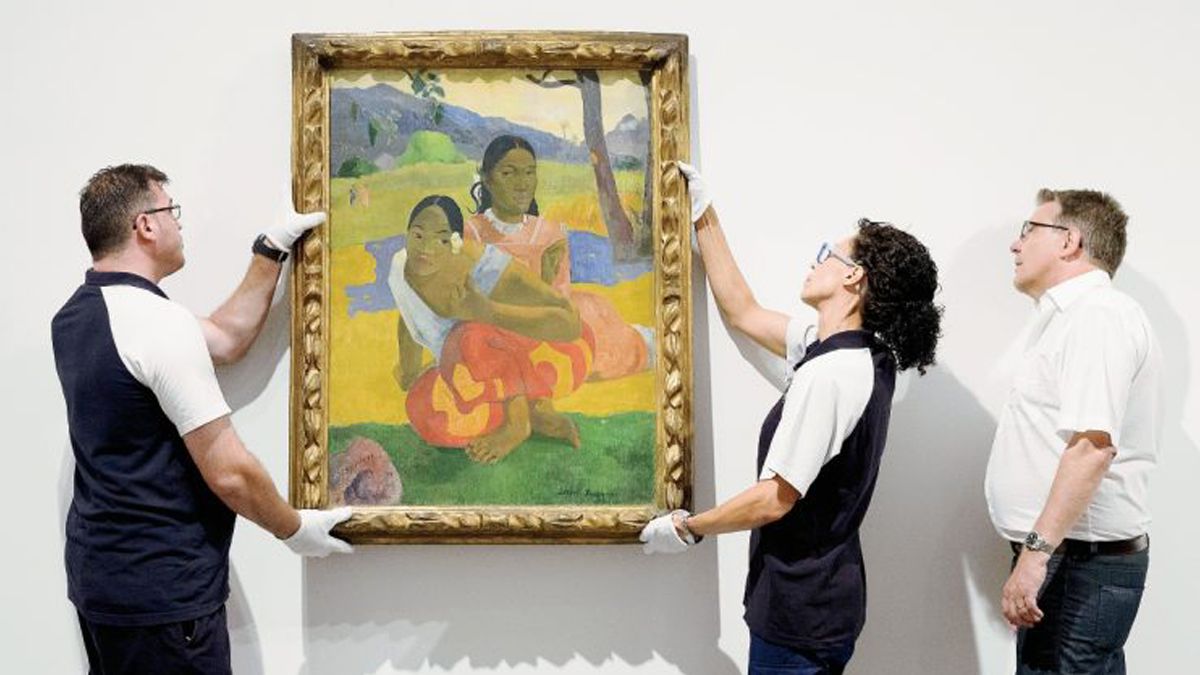 Dos empleados del Museo Reina Sofía (Madrid) instalan el cuadro de Paul Gauguins Nafea Ipoipo faa