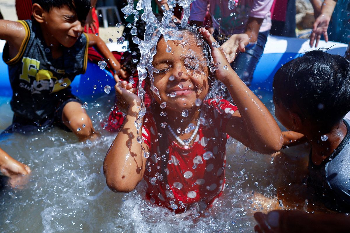 Una niña palestina nada en una piscina para refrescarse en medio de una ola de calor mientras la escasez de energía en Gaza empeoraba por el calor, provocando protestas, en Khan Younis, en el sur de la Franja de Gaza, el 17 de julio de 2023. 