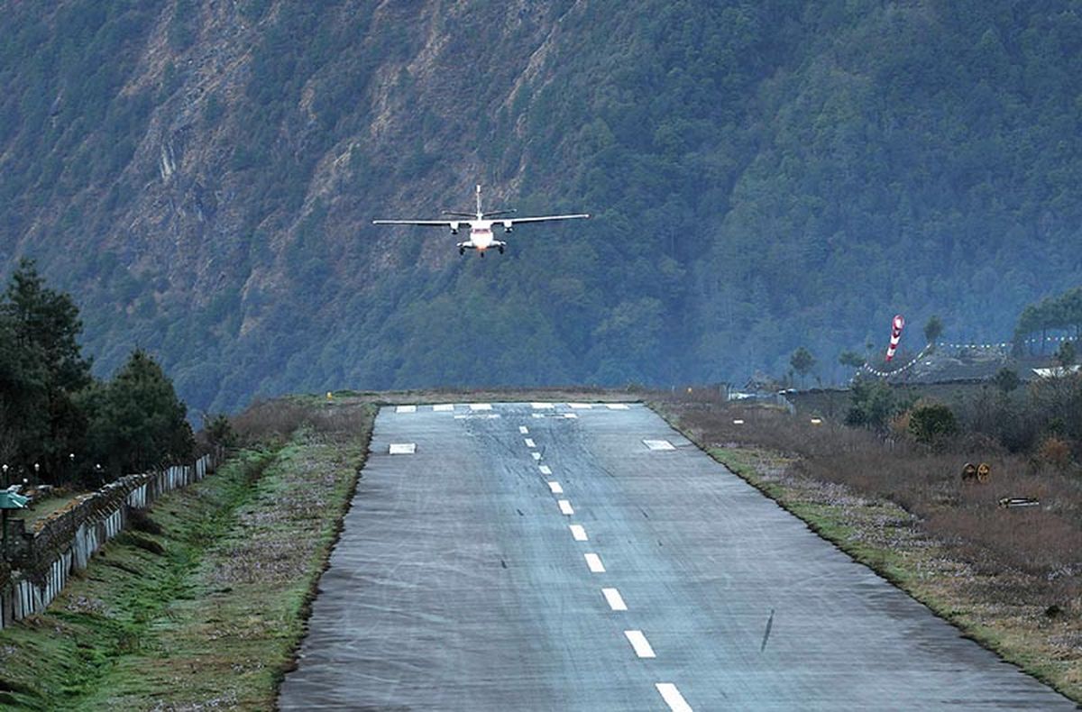 La pista de Lukla, cuya orientación es 06/24 (es decir, noreste-suroeste), mide solo 493 metros (1622 pies), equivalentes a menos de cinco cuadras de una ciudad, su ancho es de 30 metros (99 pies) y, la pendiente de la misma, es del 11,7 %. Esta inclinación ayuda a los aviones a reducir la velocidad en un aterrizaje (ya que lo hacen en subida), y a aumentarla al despegar (la carrera es en bajada). La pista de Lukla, cuya orientación es 06/24 (es decir, noreste-suroeste), mide solo 493 metros (1622 pies), equivalentes a menos de cinco cuadras de una ciudad, su ancho es de 30 metros (99 pies) y, la pendiente de la misma, es del 11,7 %. Esta inclinación ayuda a los aviones a reducir la velocidad en un aterrizaje (ya que lo hacen en subida), y a aumentarla al despegar (la carrera es en bajada).