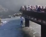 El hombre cruzó las barreras de contención y se arrojó al río para recuperar el teléfono que había perdido. El hombre cruzó las barreras de contención y se arrojó al río para recuperar el teléfono que había perdido.