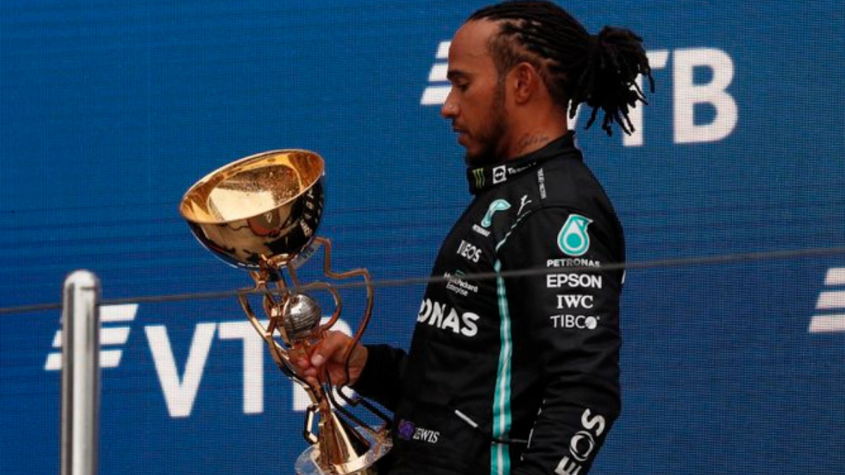 Hamilton y su trofeo tras ganar su carrera N°100 en Fórmula 1.