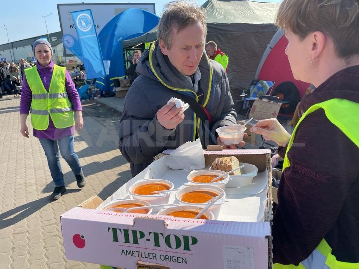 Un hombre es asistido con comida en la frontera de Ucrania con Polonia.