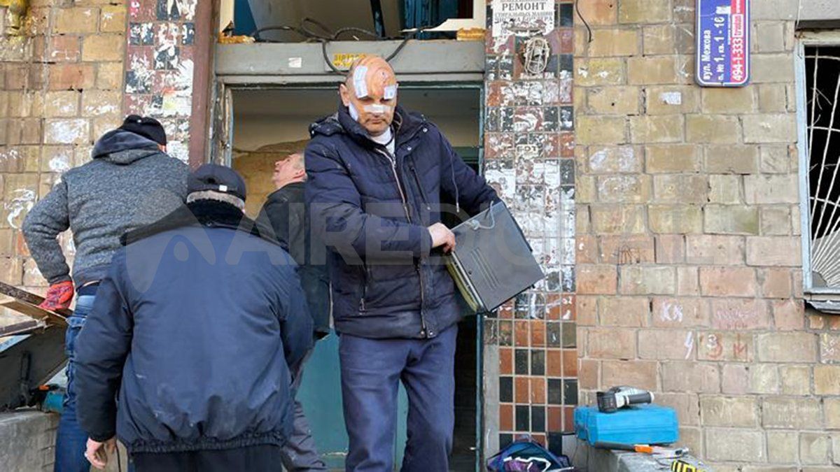 Un hombre alto, con su cabeza calva llena de cicatrices y manchas de iodo, se va con un pequeño televisor viejo bajo el brazo.