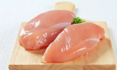 Pechugas de pollo crudas en tabla de madera. Pechugas de pollo crudas en tabla de madera.