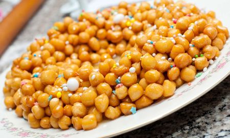 Las pignolatas son un delicioso postre italiano hecho de masa frita y cubierta con miel y piñones. Las pignolatas son un delicioso postre italiano hecho de masa frita y cubierta con miel y piñones.