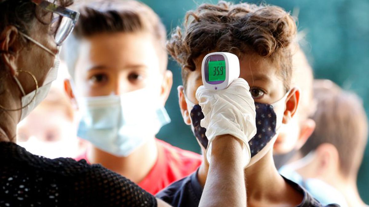 Una maestra le toma la fiebre a un alumno en Italia