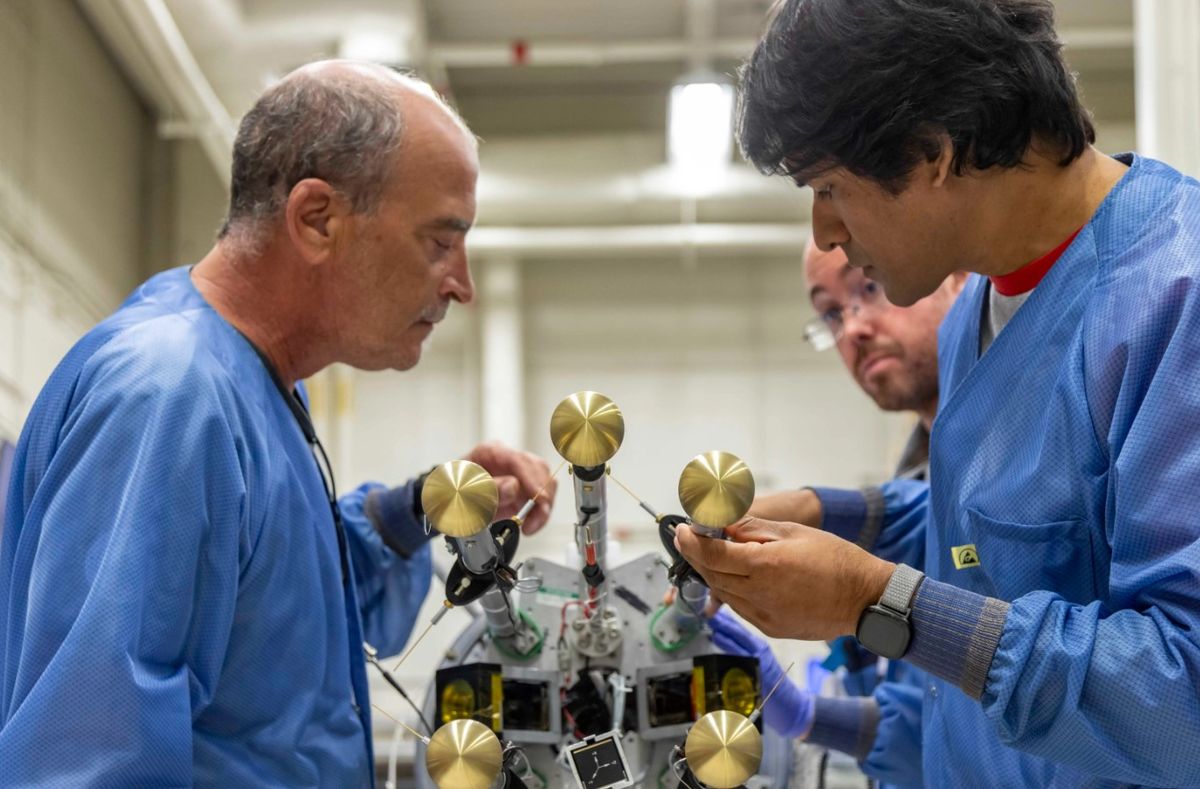 El técnico mecánico John Peterson de la Instalación de Vuelo Wallops de la NASA y Barjatya revisan los seis brazos que transportan los sensibles sensores científicos después de una exitosa prueba de despliegue de giro.