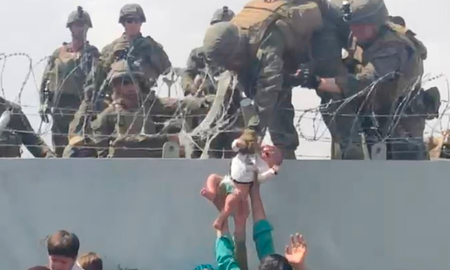 En la imagen se ve a un adulto entregando un bebe a un soldado estadounidense por encima de un alambre de púas en el aeropuerto de Kabul, que se encuentra rodeado por talibanes, pero es operado por las tropas norteamericanas para garantizar la evacuación de quienes quieran abandonar el país. En la imagen se ve a un adulto entregando un bebe a un soldado estadounidense por encima de un alambre de púas en el aeropuerto de Kabul, que se encuentra rodeado por talibanes, pero es operado por las tropas norteamericanas para garantizar la evacuación de quienes quieran abandonar el país.