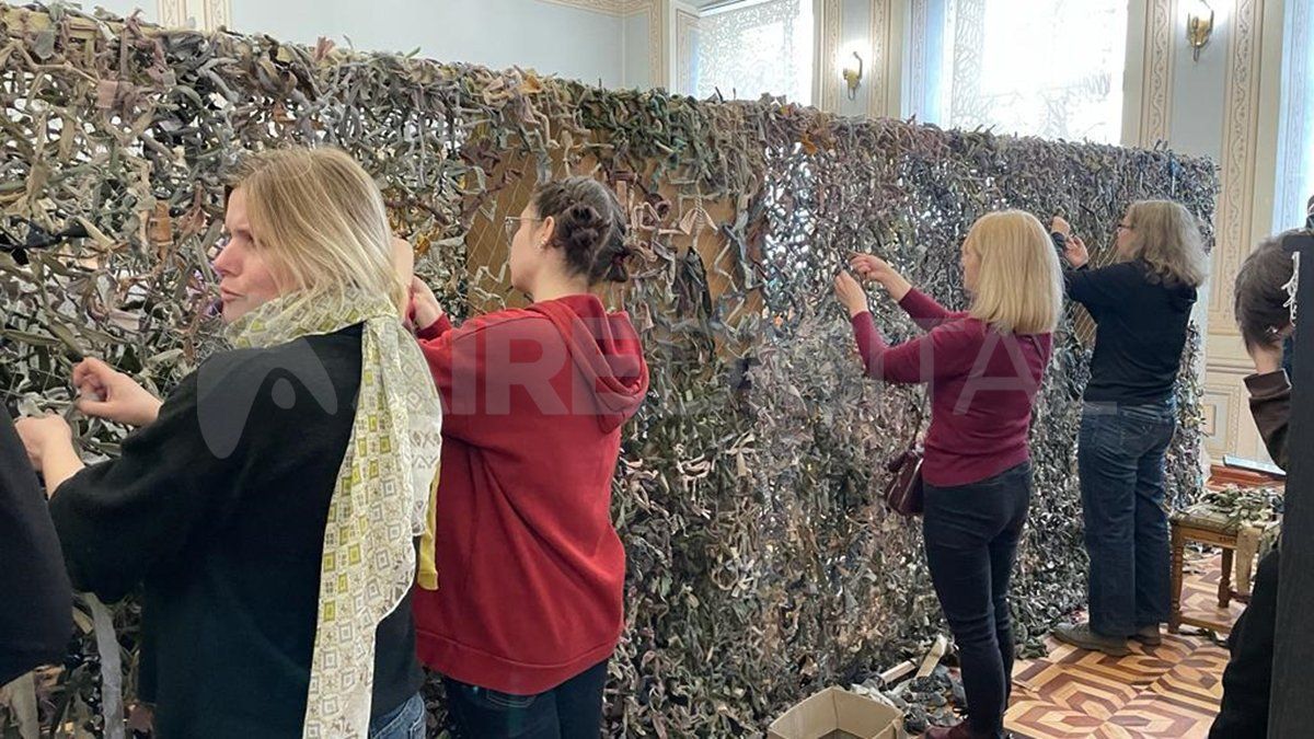 Ciudadanos ucranianos, principalmente mujeres, colaboran con el ejército realizando trajes de camuflaje en una biblioteca de Lviv.