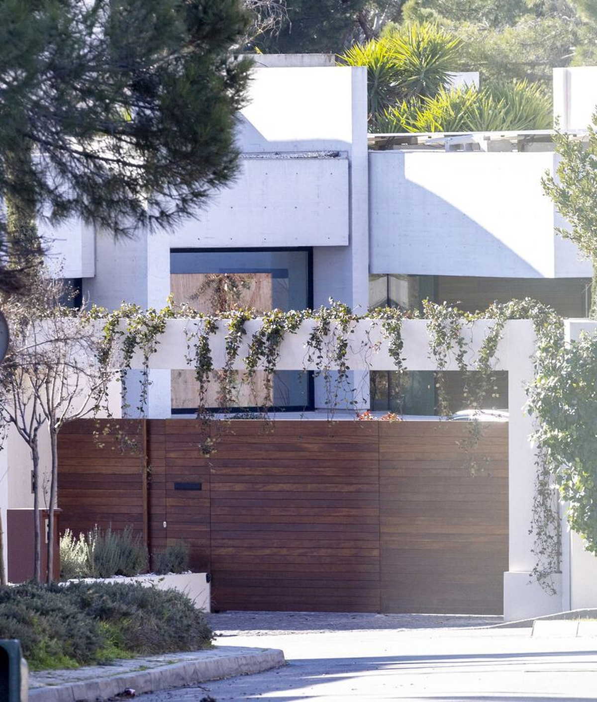 El frente de la casa cuenta con un diseño realizado en hormigón y con una gran puerta de madera, la cual, deja ver parte del ingreso a la propiedad.