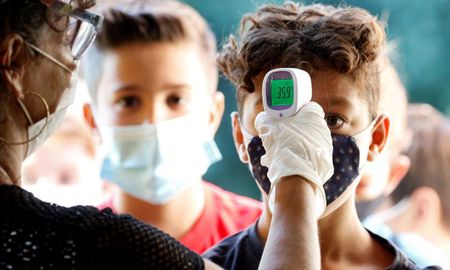 Una maestra le toma la fiebre a un alumno en Italia, en la semana en la que retomaron las clases presenciales. Una maestra le toma la fiebre a un alumno en Italia, en la semana en la que retomaron las clases presenciales.