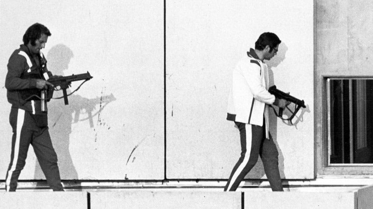 Los terroristas marchan armados en medio de la toma de rehenes. La Masacre de Munich fue uno de los actos m&aacute;s aberrantes en la historia del deporte.