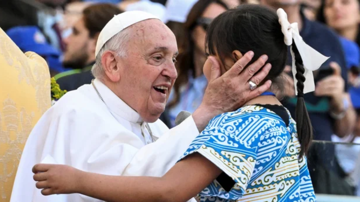 Francisco saluda a una niña durante la inauguración de la Jornada Mundial de la Infancia.