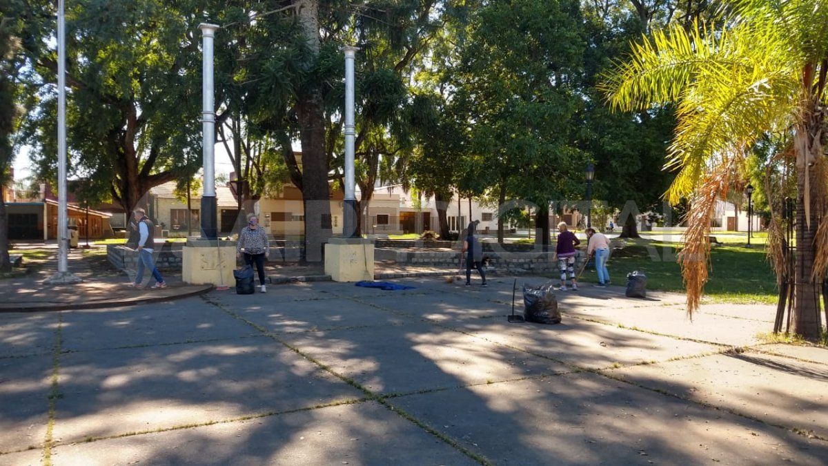 Vecinos autoconvocados realizan el mantenimiento de la plaza frente a la Basílica de Guadalupe.