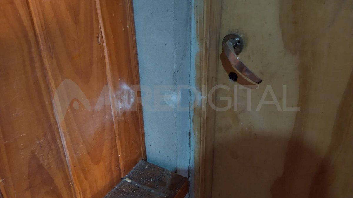 Los agujeros de las balas marcados en el machimbre y en la puerta placa.