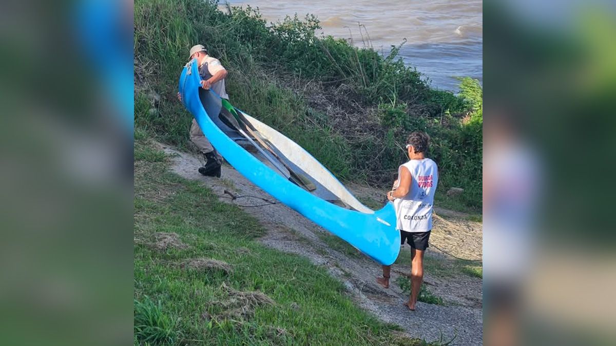 Personal que participó del operativo de búsqueda traslada el kayak utilizado por el adolescente, en el sector del río Coronda donde se concentraron los rastrillajes. Foto: Coronda Registrada.