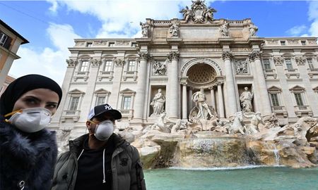 Dos turistas protegidos con máscaras en la Fontana Di Trevi en Roma - AFP Dos turistas protegidos con máscaras en la Fontana Di Trevi en Roma - AFP