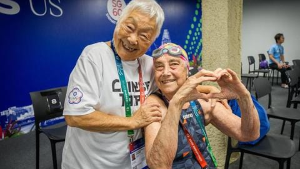 Elena Placci junto a su colega china de 96, compartiendo un abrazo y una charla en inglés, demostrando que la vitalidad no tiene fronteras.