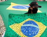 Una mujer con una bandera de Brasil con cruces por las v&iacute;ctimas del coronavirus.