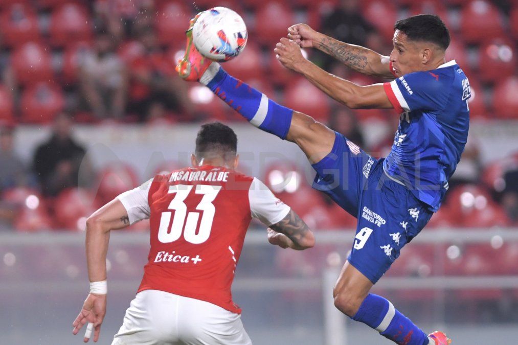 Fernando Cuqui Márquez, de Unión, disputa la pelota con Juan Manuel Insaurralde -Independiente-.