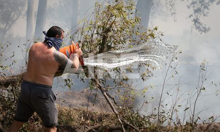 Vecinos de Rincón sacando agua del río en baldes para combatir el fuego. Vecinos de Rincón sacando agua del río en baldes para combatir el fuego.