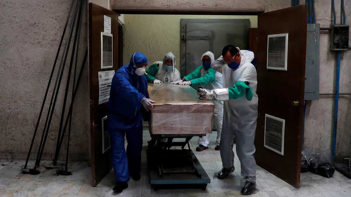 Empleados de una funeraria trasladan el ata&uacute;d de una v&iacute;ctima de Covid-19 en un crematorio de M&eacute;xico