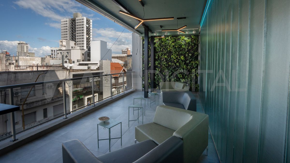 El segundo piso cuenta con un balcón verde.