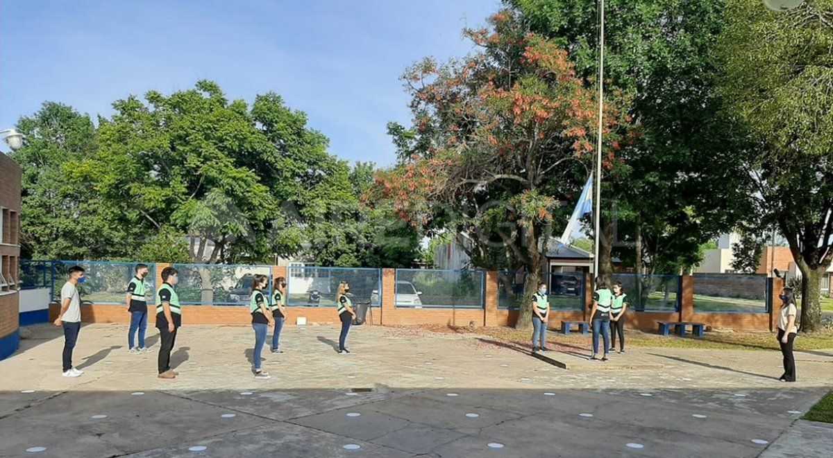 Los estudiantes izaron la bandera respetando el distanciamiento social. 
