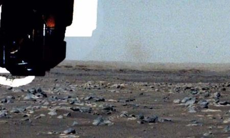 El diablo de polvo se puede ver detrás del brazo robótico del rover, en esta vista mejorada/procesada. El diablo de polvo se puede ver detrás del brazo robótico del rover, en esta vista mejorada/procesada.