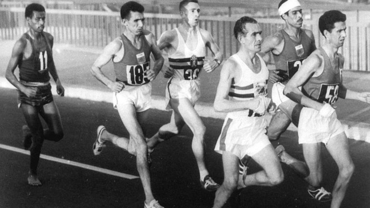 Bikila (número 11), corre descalzo por las calles de Roma junto al pelotón que, entre otros, integra el marroquí Rhadi Ben Abdesselam (185), quien sería su escolta en esta prueba. Bikila (número 11), corre descalzo por las calles de Roma junto al pelotón que, entre otros, integra el marroquí Rhadi Ben Abdesselam (185), quien sería su escolta en esta prueba.