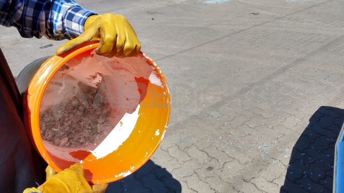 Un vecino del barrio lo ayudó para sacar los cristales rotos.