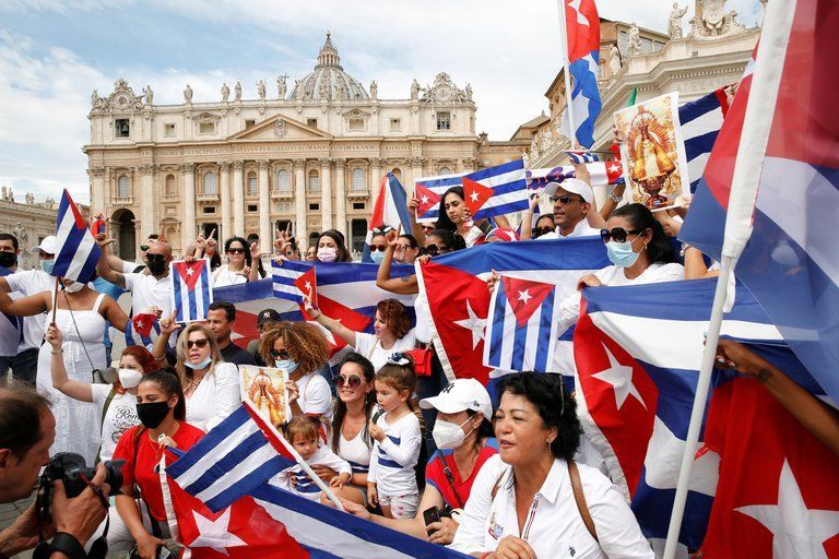 La comunidad sostiene banderas de Cuba, antes del rezo del Ángelus dirigido por el Papa Francisco, en la Plaza de San Pedro del Vaticano.