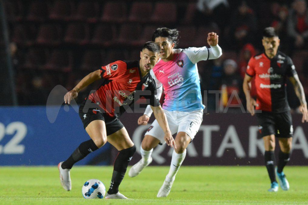Federico Lértora sale jugando ante la mirada de Marcelo Moreno Martins.