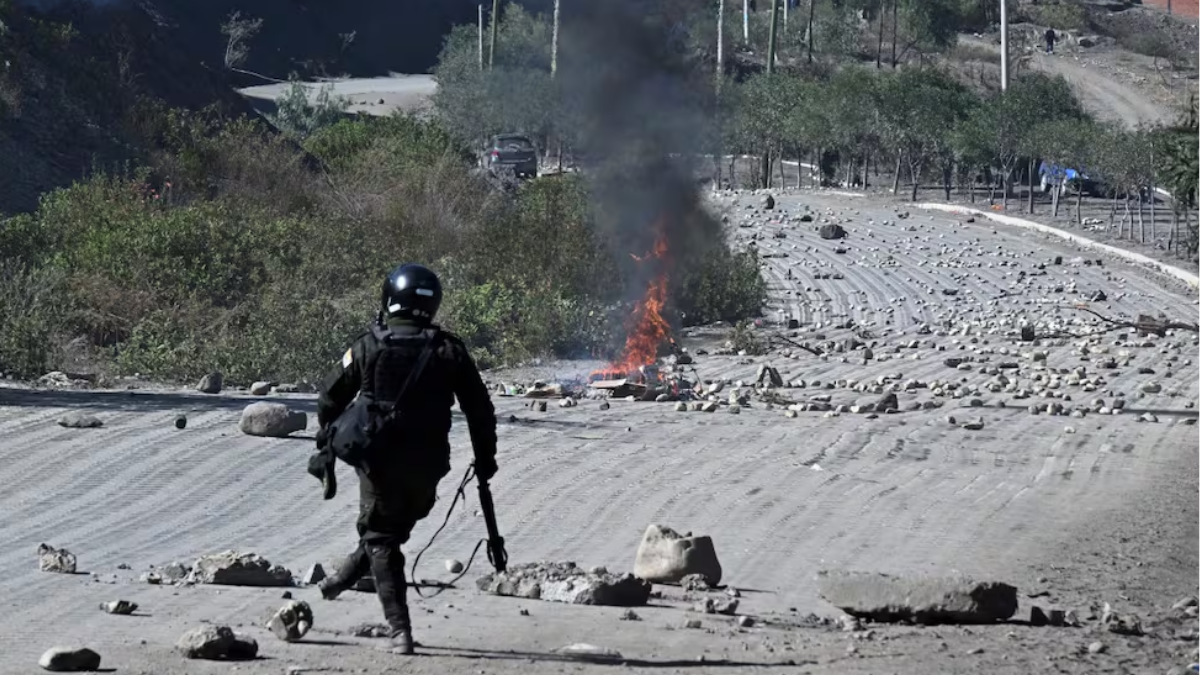 Un agente antidisturbios retira piedras de una carretera bloqueada por manifestantes rurales en Lipari, departamento de La Paz, Bolivia, el 16 de mayo de 2026. Un agente antidisturbios retira piedras de una carretera bloqueada por manifestantes rurales en Lipari, departamento de La Paz, Bolivia, el 16 de mayo de 2026.