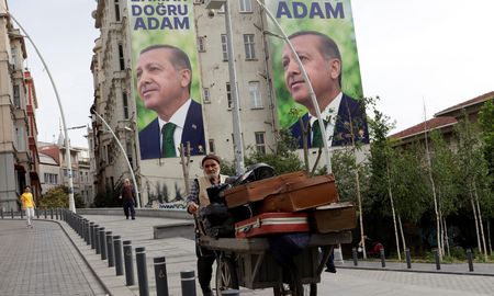 Un vendedor se abre paso en una calle, con carteles de la campaña electoral del presidente turco Tayyip Erdogan de fondo, tras la primera vuelta de las elecciones presidenciales y parlamentarias, en Estambul, Un vendedor se abre paso en una calle, con carteles de la campaña electoral del presidente turco Tayyip Erdogan de fondo, tras la primera vuelta de las elecciones presidenciales y parlamentarias, en Estambul,