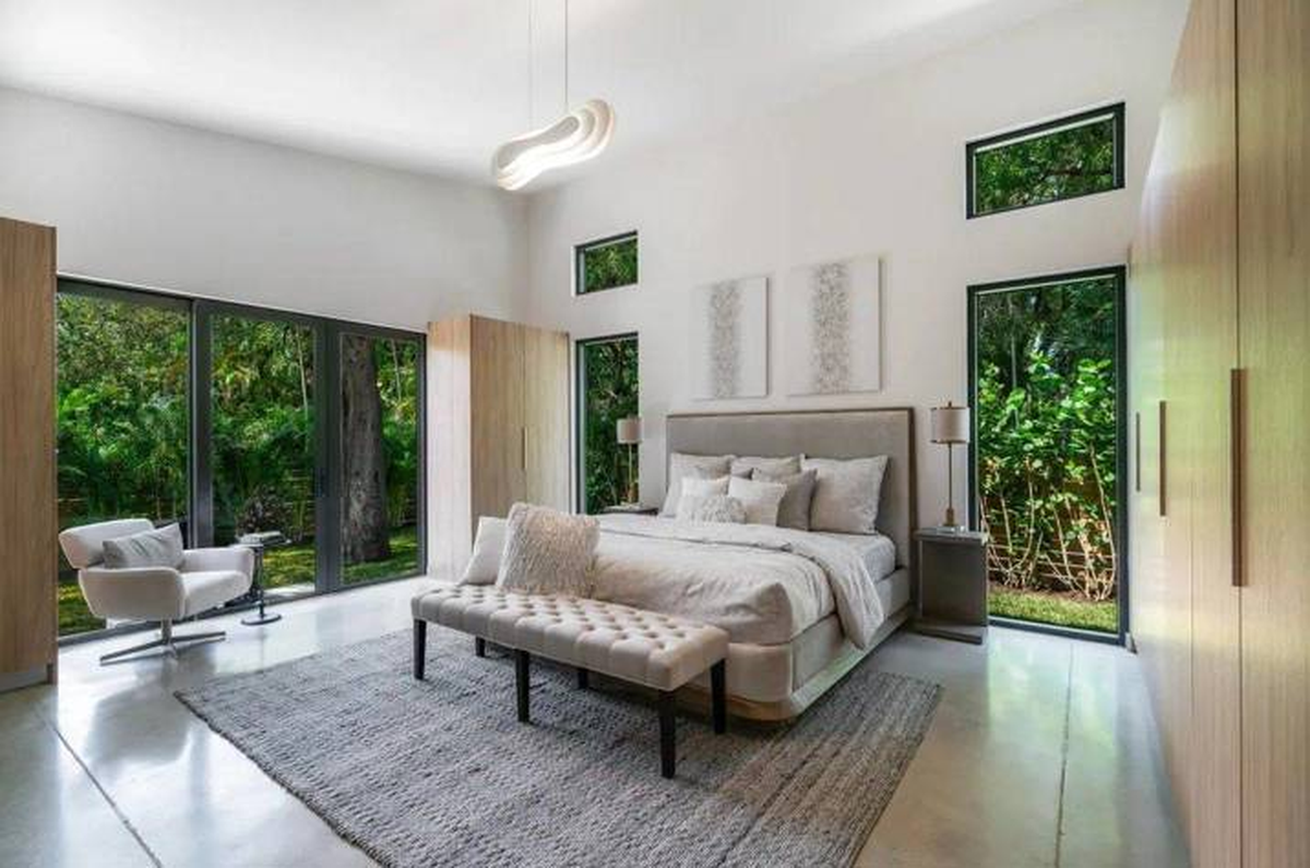 La habitación principal cuenta con vista al patio de la casa a través de grandes ventanas. La habitación principal cuenta con vista al patio de la casa a través de grandes ventanas.