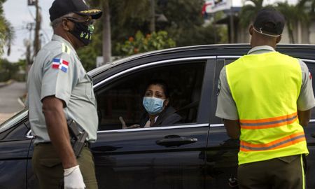 Policías revisan un auto en un puesto de control en Santo Domingo, después de que el presidente Danilo Medina decretó el toque de queda como medida preventiva contra la propagación del nuevo coronavirus. Policías revisan un auto en un puesto de control en Santo Domingo, después de que el presidente Danilo Medina decretó el toque de queda como medida preventiva contra la propagación del nuevo coronavirus.