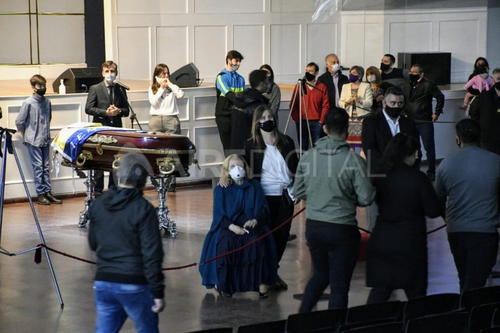 Alrededor del cajón con el cuerpo del pastor hay personal de seguridad y fieles. 