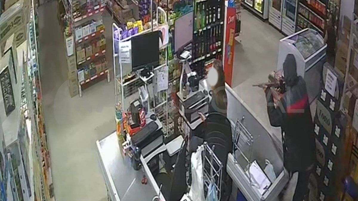El momento en que uno de los ladrones apuntaba a la cajera del minimercado.&nbsp;