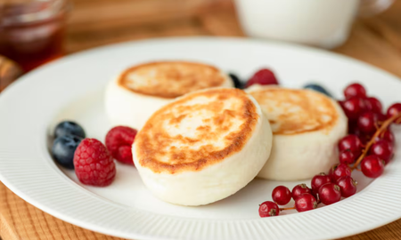 Sýrniki: tortitas de queso fresco, suaves por dentro y doradas por fuera, perfectas para un desayuno o merienda. Sýrniki: tortitas de queso fresco, suaves por dentro y doradas por fuera, perfectas para un desayuno o merienda.
