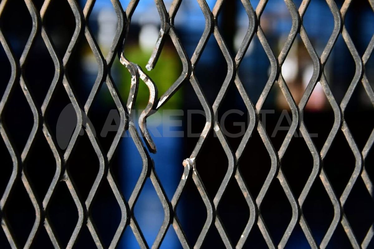 Los orificios de las balas en la reja de la institución.