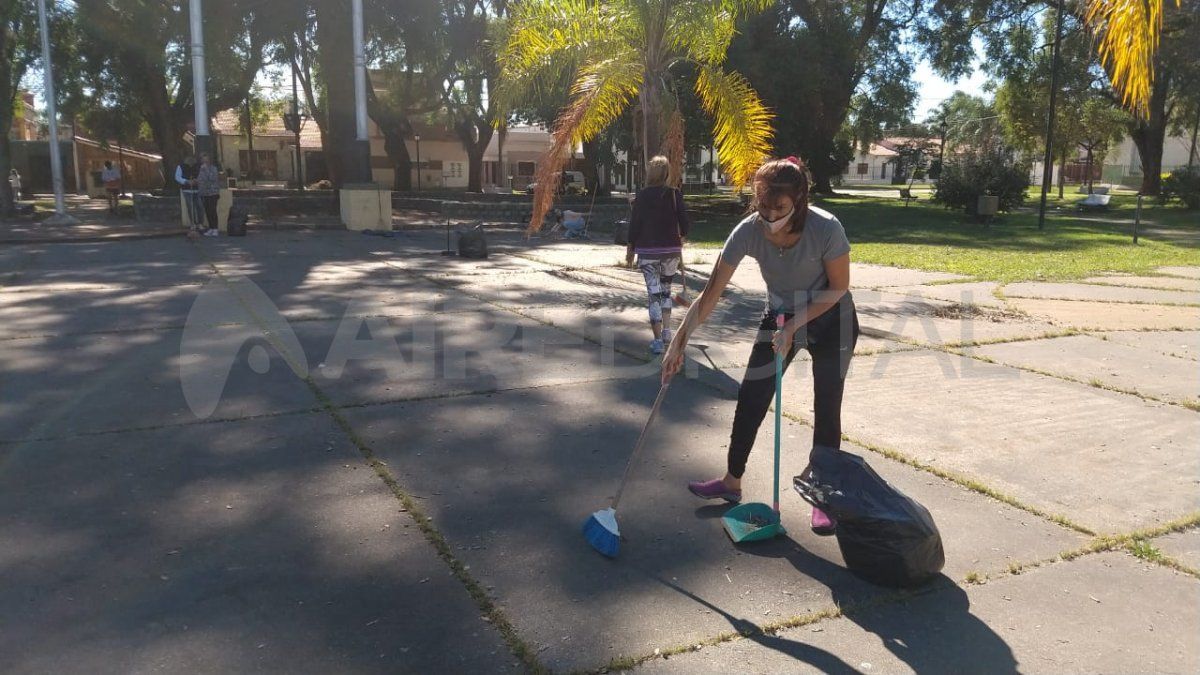 Vecinos autoconvocados realizan el mantenimiento de la plaza frente a la Basílica de Guadalupe.