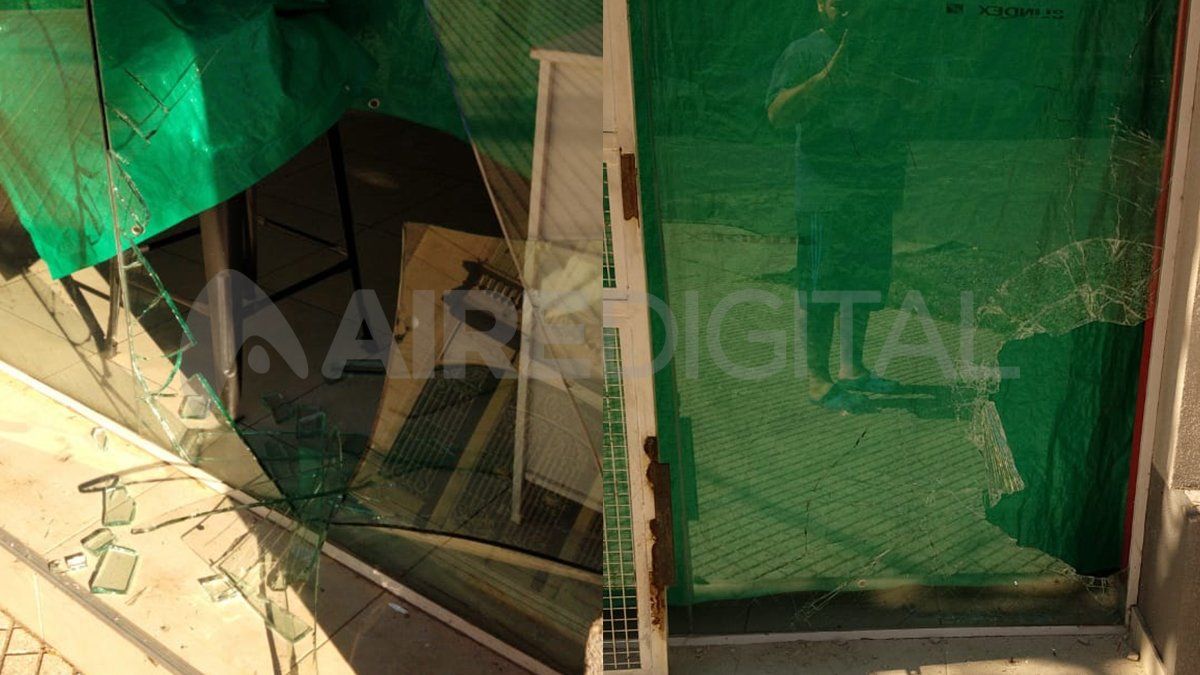 Dos fotos en una: a la izquierda, el vidrio destrozado durante el primer robo en enero y, a la derecha, la vidriera destruida ayer a la madrugada