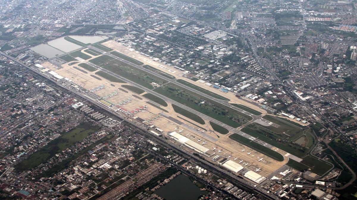Vista general del Aeropuerto Internacional Don Mueang desde el noreste. Es una instalación de uso conjunto, que combina las operaciones de las compañías comerciales civiles (cuya plataforma se advierte en primer plano) con las de la 1ª División Aérea de la RTAF (al fondo), y el campo de golf entre las pistas. Vista general del Aeropuerto Internacional Don Mueang desde el noreste. Es una instalación de uso conjunto, que combina las operaciones de las compañías comerciales civiles (cuya plataforma se advierte en primer plano) con las de la 1ª División Aérea de la RTAF (al fondo), y el campo de golf entre las pistas.