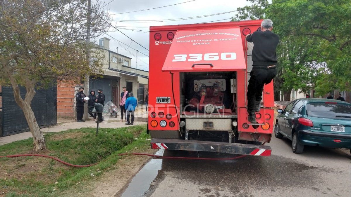 Los bomberos apagan las llamas en la vivienda de barrio Transporte.