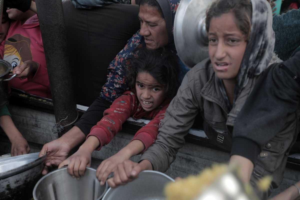 Palestinos esperan para recibir comida de un centro de distribución de alimentos