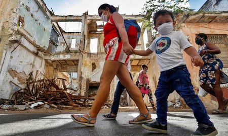Varias personas caminan por la calle usando mascarillas para protegerse del coronavirus en La Habana (CUBA). Varias personas caminan por la calle usando mascarillas para protegerse del coronavirus en La Habana (CUBA).