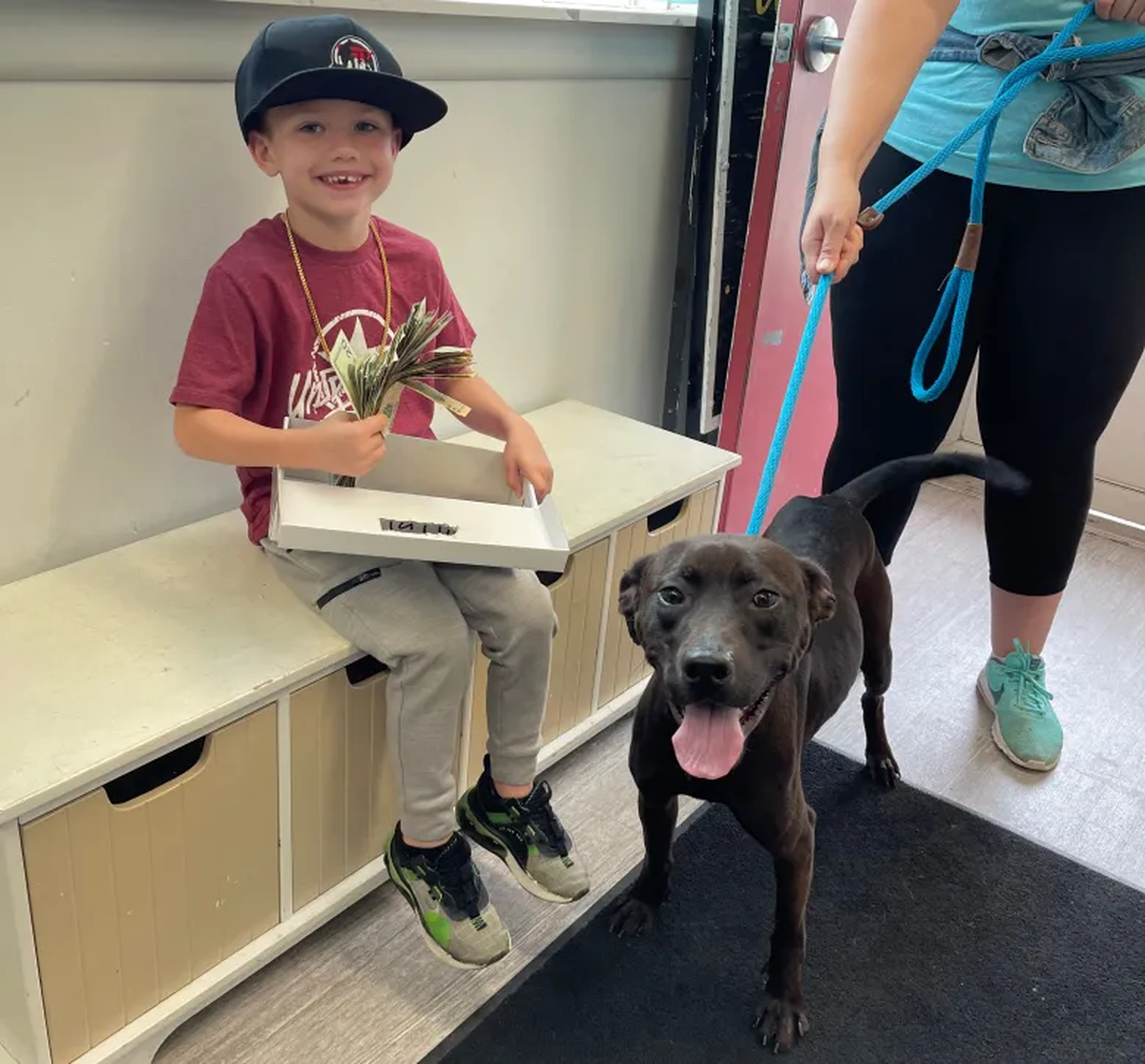 Henry con su recaudación junto a Bear, uno de los perros del refugio de animales. 