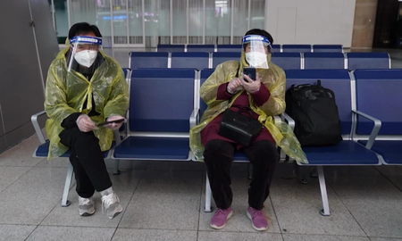 Dos personas con protección sanitaria en Beijing. Dos personas con protección sanitaria en Beijing.