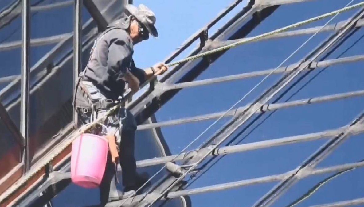 El video del momento en que un limpiavidrios trabaja a 115 metros de altura agarrado de una soga